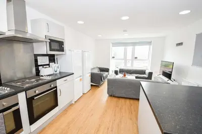 a kitchen and a living room with a couch at Spacious 13 Bedroom Apartment in Liverpool in Liverpool