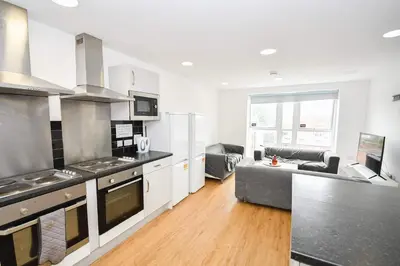 a kitchen and living room with a couch at Spacious 13 Bedroom Apartment in Liverpool in Liverpool