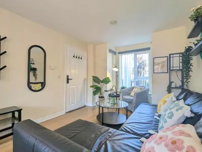 a living room with a blue couch and a table at Stylish 4-Bed, 3-Bath Townhouse with Free Parking in Liverpool