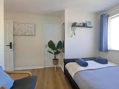 a bedroom with a bed and a potted plant at Stylish 4-Bed, 3-Bath Townhouse with Free Parking in Liverpool