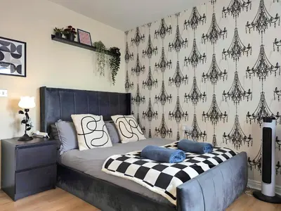 a bedroom with a bed with a black and white patterned wall at Stylish 4-Bed, 3-Bath Townhouse with Free Parking in Liverpool