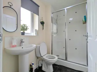 a bathroom with a toilet and a sink and a shower at Stylish 4-Bed, 3-Bath Townhouse with Free Parking in Liverpool