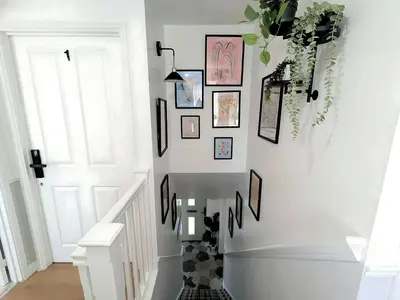 a stairway with a bunch of pictures on the wall at Stylish 4-Bed, 3-Bath Townhouse with Free Parking in Liverpool