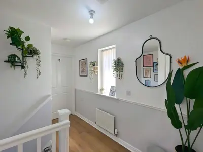 a white hallway with a mirror on the wall at Stylish 4-Bed, 3-Bath Townhouse with Free Parking in Liverpool
