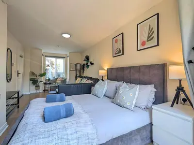 a bedroom with a large bed with blue pillows at Stylish 4-Bed, 3-Bath Townhouse with Free Parking in Liverpool