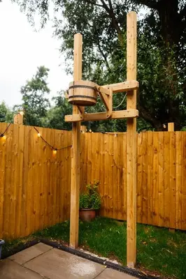 a wooden bird feeder in front of a fence at The Southworth Spa at Samlesbury Hall in Samlesbury
