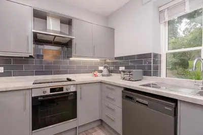 a kitchen with white cabinets and a sink at Parson Castle View, Sleeps 6, Clitheroe Centre in Clitheroe