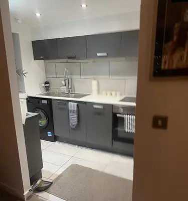 a kitchen with a sink and a washing machine at Liverpool City Centre Apartment with view in Liverpool