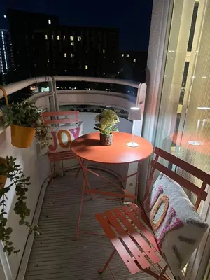 a table and chairs on a balcony with a view of a city at Liverpool City Centre Apartment with view in Liverpool