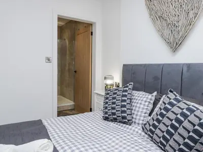 a bedroom with a bed with blue and white pillows at Holy Trinity Cottage in Millom