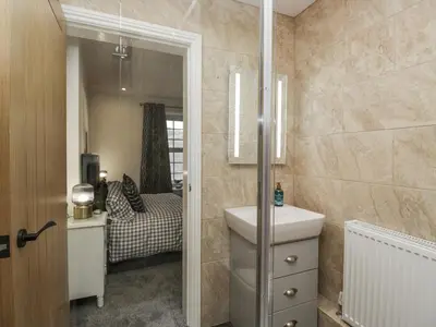 a bathroom with a sink and a mirror at Holy Trinity Cottage in Millom