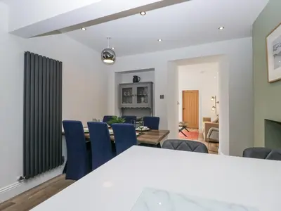 a dining room and living room with a table and chairs at Holy Trinity Cottage in Millom