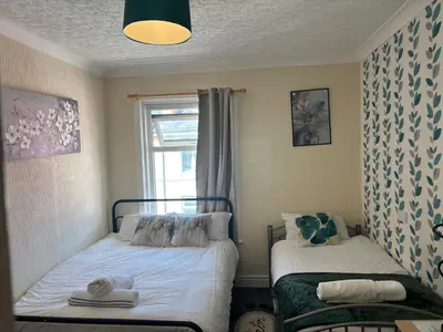 a small bedroom with two beds and a window at Affordable Golden Mile Hotel In Blackpool Close To The Beach And Blackpool City Centre With Free Street Parking Subject To Availabilty in Blackpool