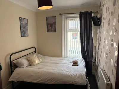 a bed in a room with a window and a bed sidx sidx sidx at Affordable Golden Mile Hotel In Blackpool Close To The Beach And Blackpool City Centre With Free Street Parking Subject To Availabilty in Blackpool