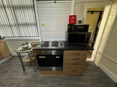 a kitchen with a stove top oven and a microwave at Ground Floor Cute & Cozy - 1 Person Studio - South Pier in Blackpool