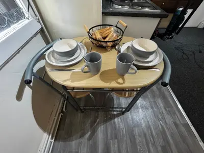 a table with plates and cups and dishes on it at Ground Floor Cute & Cozy - 1 Person Studio - South Pier in Blackpool