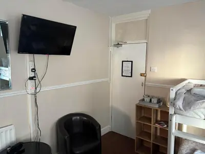 a room with a bed and a television on a wall at The Lynbar Hotel in Blackpool