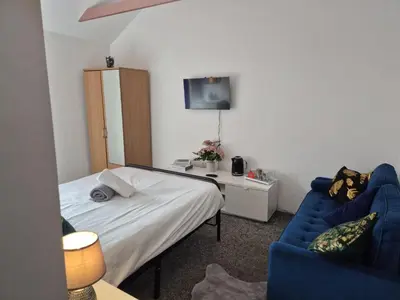 a bedroom with a bed and a blue couch at New Central Guest House in Blackpool