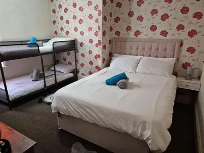 a bedroom with a bed and two bunk beds at New Central Guest House in Blackpool