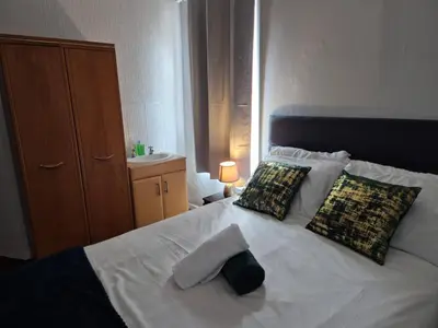 a bedroom with a white bed with two pillows at New Central Guest House in Blackpool