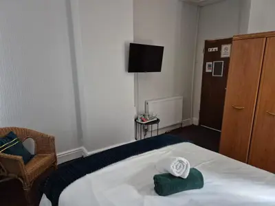 a hotel room with a bed and a tv at New Central Guest House in Blackpool