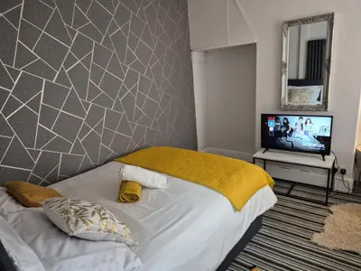 a bedroom with a bed and a television in it at New Central Guest House in Blackpool