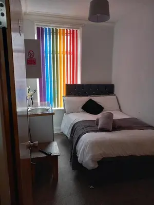 a bedroom with two beds and a rainbow window at New Central Guest House in Blackpool