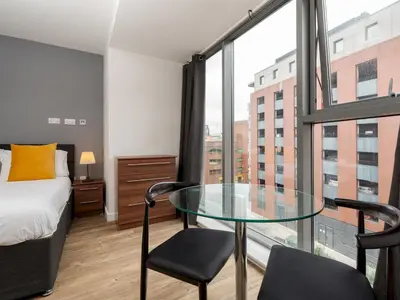 a bedroom with a glass table in front of a window at Pass the Keys Stylish Flat Near Moorfields Stn in Liverpool