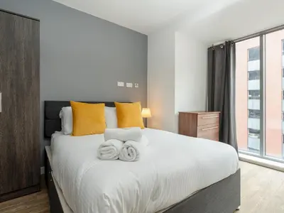 a bedroom with a large bed with towels on it at Pass the Keys Stylish Flat Near Moorfields Stn in Liverpool