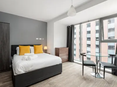 a bedroom with a bed and a glass table at Pass the Keys Stylish Flat Near Moorfields Stn in Liverpool