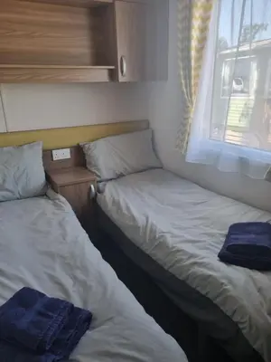 two beds in a small room with a window at Leafy Lytham Holiday Home in Warton
