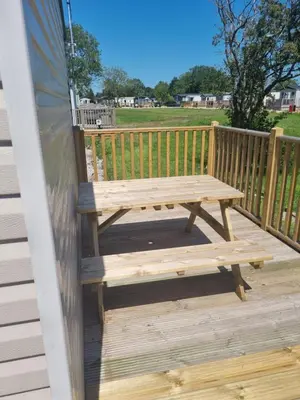 a wooden bench on the deck of a house at Leafy Lytham Holiday Home in Warton