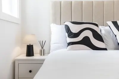a bed with a black and white pillow and a lamp at Stylish 4 Bed House In Chorley in Chorley