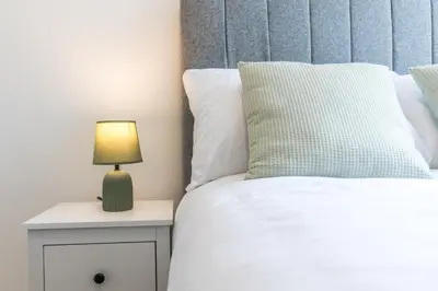 a bedroom with a bed and a lamp on a nightstand at Stylish 4 Bed House In Chorley in Chorley