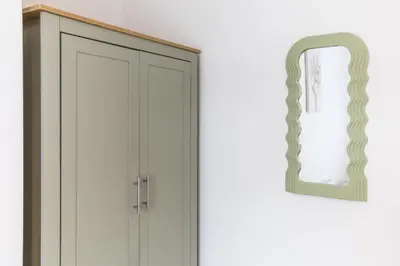 a white cabinet with a mirror next to it at Stylish 4 Bed House In Chorley in Chorley