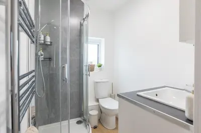 a bathroom with a shower and a toilet and a sink at Stylish 4 Bed House In Chorley in Chorley