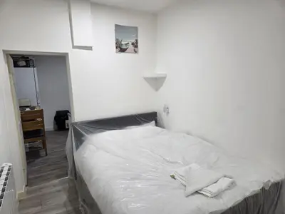 a bed in a bedroom with a white wall at Preston Studio Flat in Preston