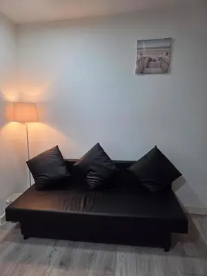 a black bed in a room with a lamp at Preston Studio Flat in Preston