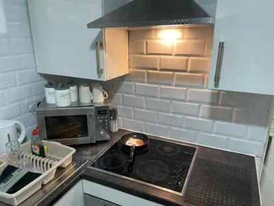a kitchen with a stove and a microwave at Preston Studio Flat in Preston