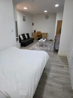 a bedroom with a bed and a living room at Preston Studio Flat in Preston