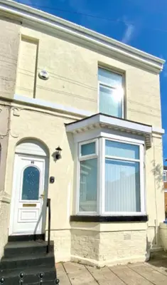 a white house with a white door and stairs at stay anfield in Liverpool