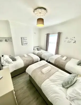 a room with four beds in a row at stay anfield in Liverpool