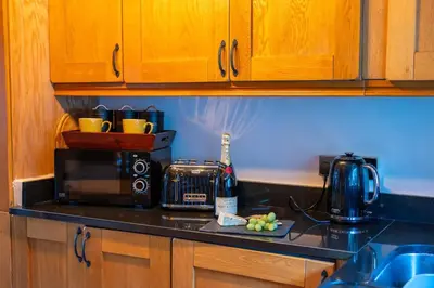 a kitchen with a counter top with a microwave and a counter top at Nettle Cottage in Heysham