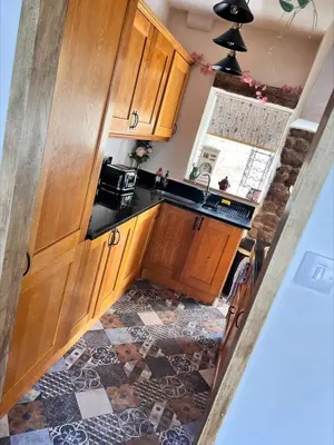 an overhead view of a kitchen with wooden cabinets at Nettle Cottage in Heysham