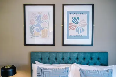 two framed posters on a wall above a bed at High End 2 Bedroom with Parking and City Access in Liverpool