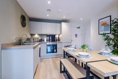 a kitchen and dining room with a wooden table and a dining room gmaxwell gmaxwell gmaxwell at High End 2 Bedroom with Parking and City Access in Liverpool