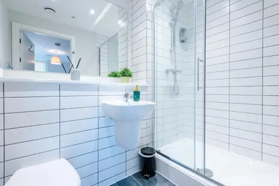 a white bathroom with a sink and a shower at High End 2 Bedroom with Parking and City Access in Liverpool