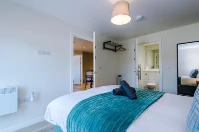 a bedroom with a large bed with a blue blanket at High End 2 Bedroom with Parking and City Access in Liverpool