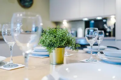 a table with wine glasses and a potted plant on it at High End 2 Bedroom with Parking and City Access in Liverpool