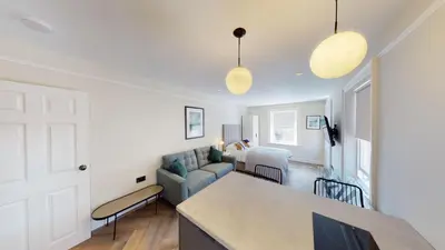 a kitchen and living room with a blue couch at Cathedral Views Heart of City Communal Laundry in Liverpool